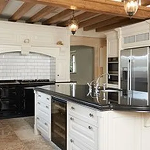 a kitchen with white cabinets and black countertops