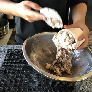 a person mixing ice cream into a bowl