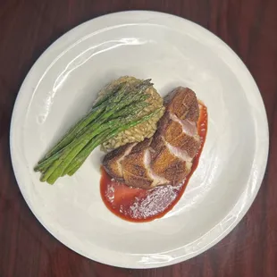Pan seared duck breast with mushroom herb risotto, roasted asparagus and a cherry gastrique.