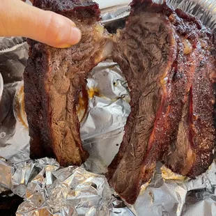 a hand holding a piece of meat