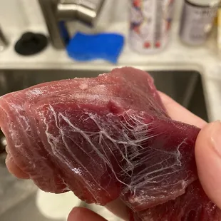 a person holding a piece of raw meat