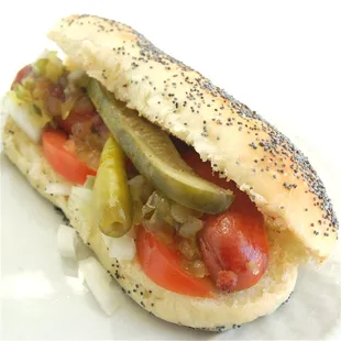 a hot dog with pickles and tomatoes