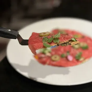 AB Pizza: Raw Australian Wagyu Beef w/ crispy tortilla, ponzu aioli, green olive, microgreens, shallots, white truffle oil ($29)