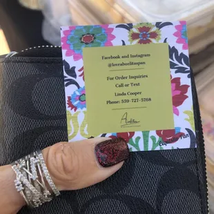 a hand holding a business card