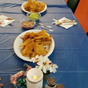 a long table with plates of chips and condiments
