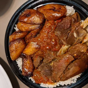 Stew with Got meat and fried plantains over rice