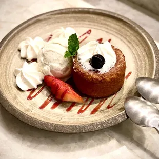 a plate of dessert with strawberries and whipped cream