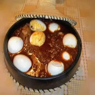 a bowl of stew with hard boiled eggs