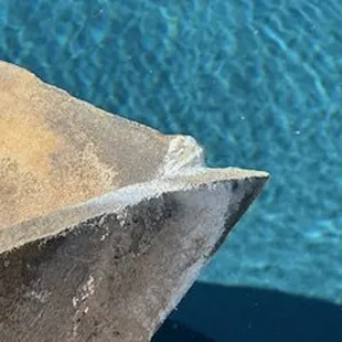 jagged, broken edge of stone with caulking trying to cover up the damaged corner