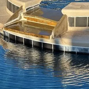 brown stone with heavy white caulking installed from spa to pool - looks horrible with the black tile on the pool