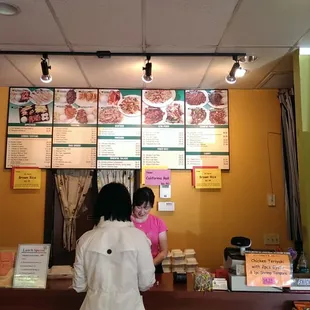 a woman standing at the counter of a restaurant