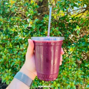 a hand holding a purple smoothie