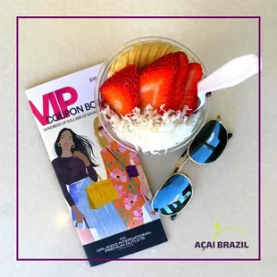 a bowl of strawberries and a book