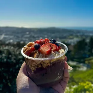 a hand holding a cup of food