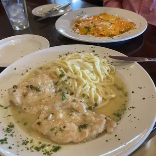 Chicken piccata and ravioli in the back with rose sauce