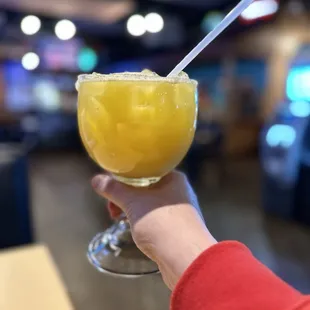 a person holding a glass of orange juice