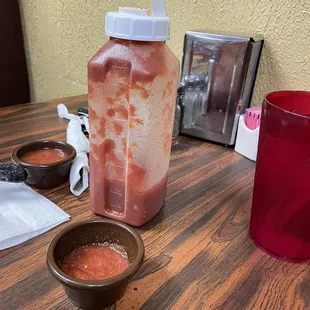 a bottle of ketchup and a bowl of sauce