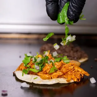 a hand sprinkling some cilantro