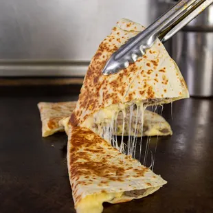 a piece of quesadilla being held by a fork