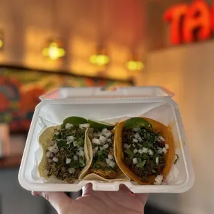 two tacos in a styrofoam container