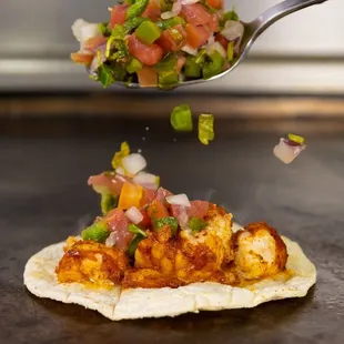 a spoon lifting a taco from a tortilla