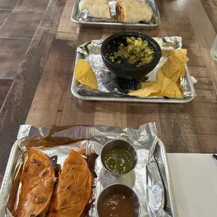 Birria tacos (bottom), guacamole (middle), Coca Cola carnitas burrito (top)