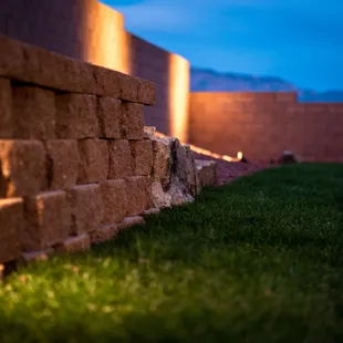 a brick retaining wall with lights