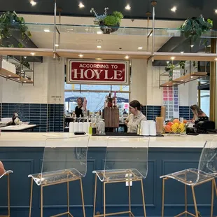 a restaurant counter with chairs and a sign that reads welcome to hoyle
