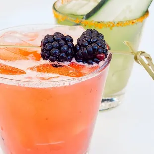 two cocktails with garnish garnish