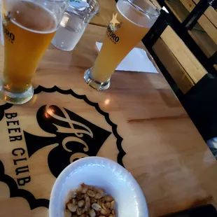 a bowl of nuts and a glass of beer