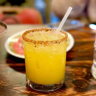 a glass of orange juice on a table