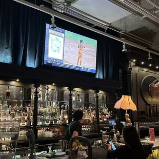 a bar with a large screen in the background