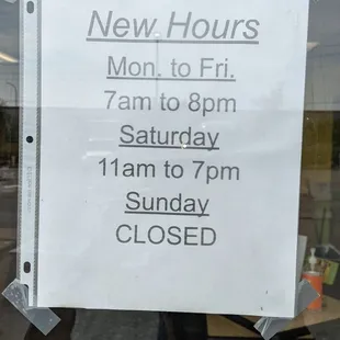 a new hours sign in a store window