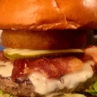 a burger with bacon, lettuce, and cheese