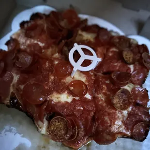 a slice of pizza with a peace sign on it