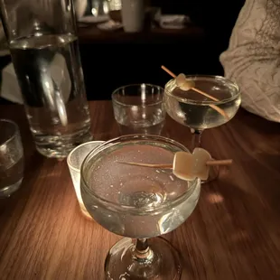 a close up of a martini glass with a toothpick on the rim