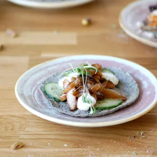 ÁRABE Lebanese spice grilled pork, onions, cilantro crema, marinated cucumber.