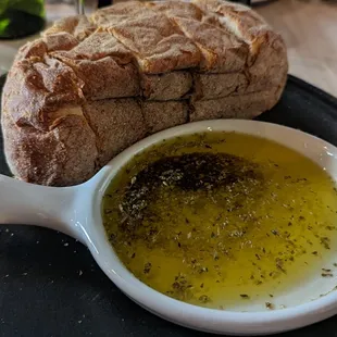 Warm bread loaf with seasoned olive oil for dipping