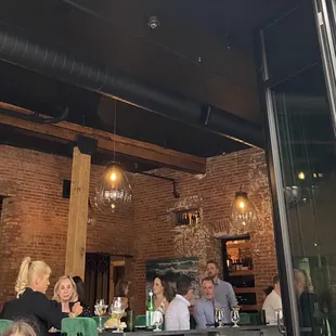 The interior dining room is rustic meets modern as is on keeping with the neighborhood.  Doorway to the right is a bricked in wine room.
