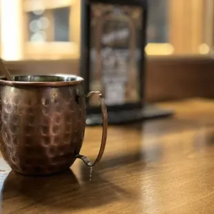 a copper mug on a wooden table