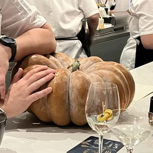 a chef putting a pumpkin on a table