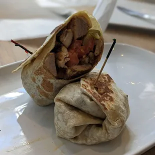 a burrito cut in half on a plate