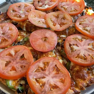 sliced tomatoes on a pizza