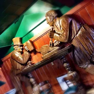 a statue of two men at a bar