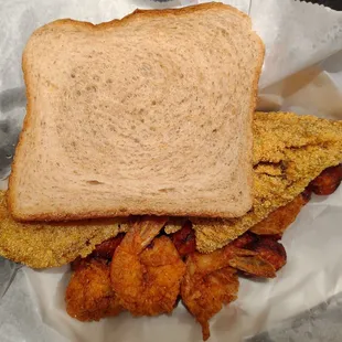 Two pieces of red snapper, four shrimp, sweet potato tots, and a slice of wheat bread