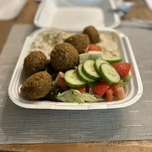 The delicious vegetarian plate has several large felafel balls, stuffed grape leaves, hummus, babaganoush, &amp; a salad with feta.