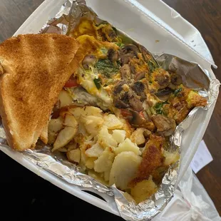 Veggie omelet with extra mushrooms, cheese and spinach. Half hash browns, half grits and cheese (grits not pictured).