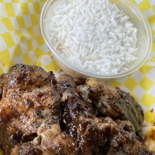 Jerk Chicken Wings with a side of rice.  The meat was cooked so perfectly tender it was falling off of the bone!