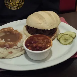 Bourbon brisket sandwich with mashed potatoes and gravy and baked beans