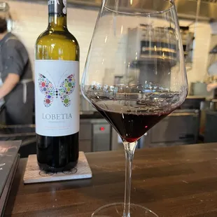 Delicious bottle of Tempranillo and a glass that is about to be refilled.